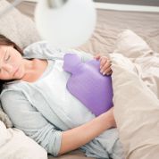Frau mit Bettflasche im Bett Frau mit Bettflasche im Bett